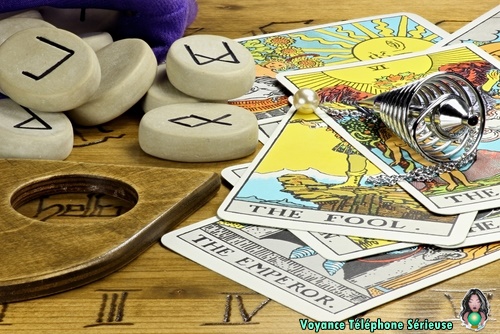 cartes de voyance Ã©talÃ©es sur une table de oui ja, tarot, runes et pendule de voyance